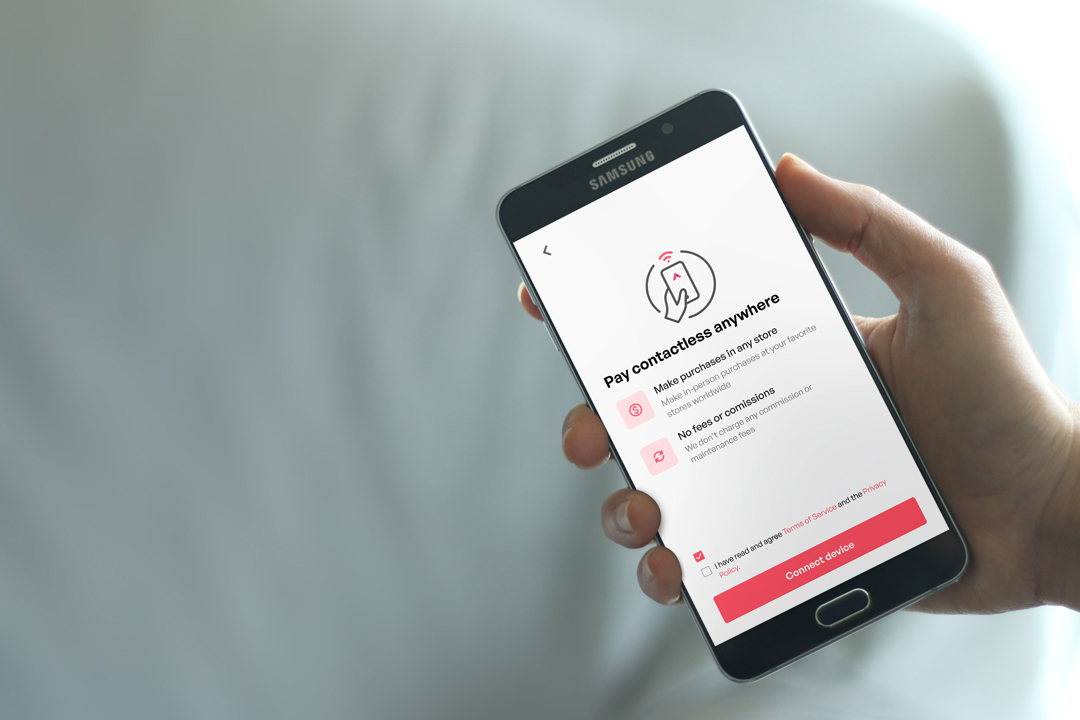 Foto de una persona sosteniendo una foto que muestra pagos sin contacto con un teléfono Android